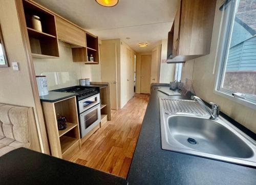 a kitchen with a large sink and a stove at Meadow View Horizon Static Caravan in Barnstaple