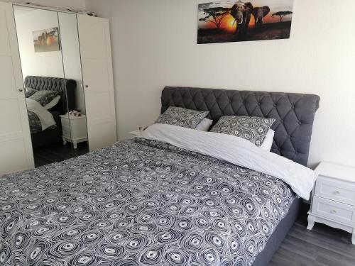 a bedroom with a large bed with a gray headboard at La Galène chambre chez l'habitant in Illkirch-Graffenstaden