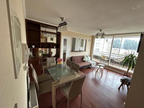 uma cozinha e sala de estar com mesa e cadeiras em Cómodo departamento en San Pedro de la Paz em San Pedro de la Paz