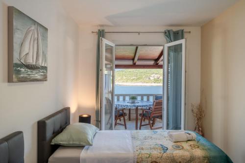 1 Schlafzimmer mit einem Bett und einem Balkon mit einem Tisch in der Unterkunft Apartments Ranko in Zavalatica
