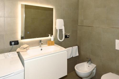 a bathroom with a sink and a toilet and a mirror at La Piccola Bellagio in Bellagio
