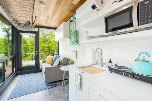 een keuken met witte werkbladen en een woonkamer bij Cute Riverside Cabin w Hot Tub Fire Pit & Kayaks in Rileyville