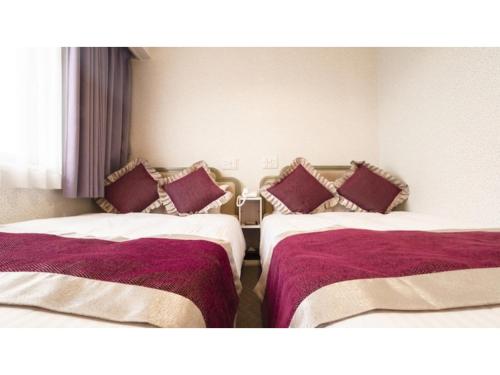 朝来市にあるHotel AreaOne Wadayama - Vacation STAY 10548vのホテルルーム 紫色の枕 ベッド2台付