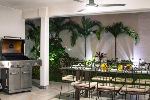 a restaurant with a table and chairs and palm trees at Casa Nicolasa Alberca y Asador Privados. in Puerto Vallarta