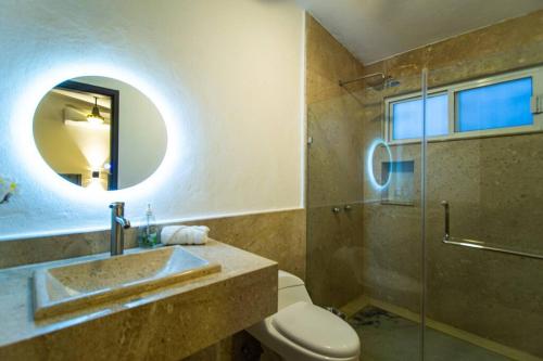 Un baño con lavabo, inodoro y espejo. en Casa Nicolasa Alberca y Asador Privados., en Puerto Vallarta