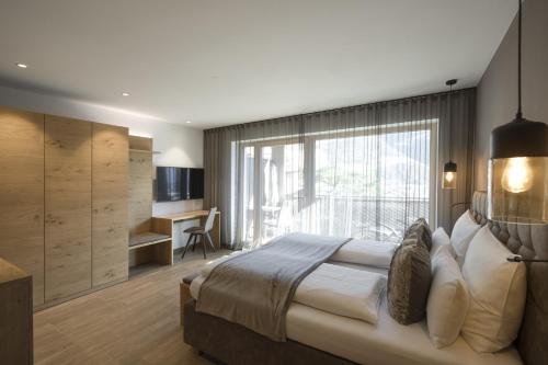 1 dormitorio con 1 cama grande y ventana grande en Residence Sonja - Apartment Fagus, en Rablà