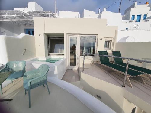 a balcony with chairs and a swimming pool on a house at Caldera's Majesty in Imerovigli
