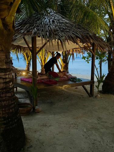 a woman laying on a beach under an umbrella at KALUME' Eco Boutique Resort-Adult only in Koh Kradan