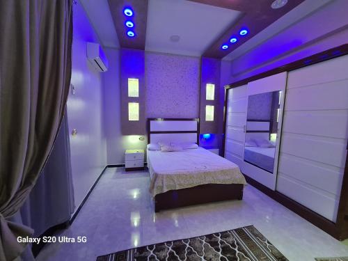 Un dormitorio con una cama con luces moradas. en Moon Adam hostel en ‘Ezbet Abu Ḥabashi