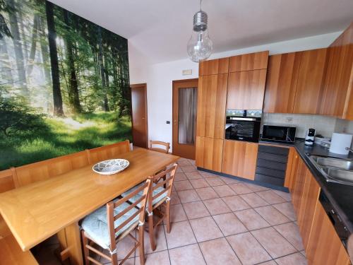 a kitchen with a wooden table and a dining room at La Veranda Alpago in Pieve dʼAlpago