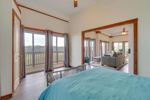 a bedroom with a large bed and a balcony at Waterfront Spicewood Home Deck, Fire Pit and Grill in Spicewood
