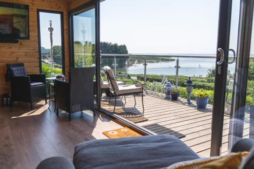 a screened in porch with a view of the ocean at Horse Island View Luxury Retreat in Kircubbin