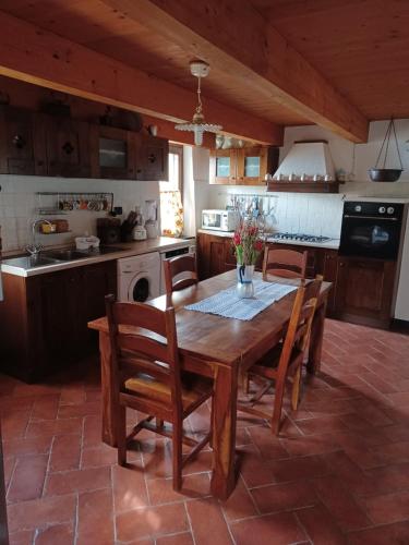 a kitchen with a wooden table and wooden chairs at Il Fontolo in Ponzano Superiore