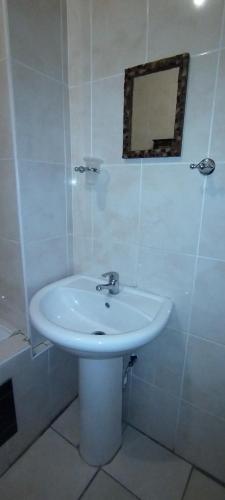 a white sink in a bathroom with a mirror at A Beach Condo in Durban