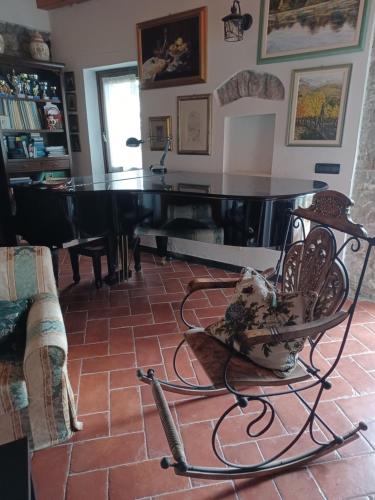 a living room with a piano and a chair at Il Fontolo in Ponzano Superiore