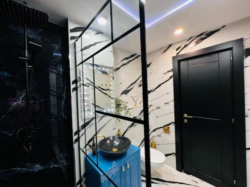 a bathroom with a blue cabinet and a glass wall at Apartament Plaja Neversea in Constanţa