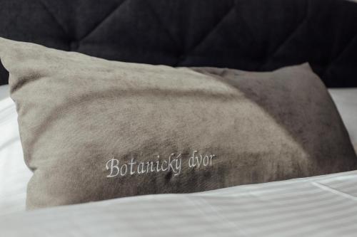 a pillow on a bed with a brown pillow with the word bathroomerror at Botanický dvor in Banská Štiavnica