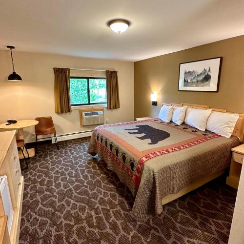 Habitación de hotel con cama grande y escritorio. en Spirit Lake Lodge en Grand Lake