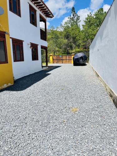 a driveway of a house with a car parked next to it at Casa turquesa in Villa de Leyva