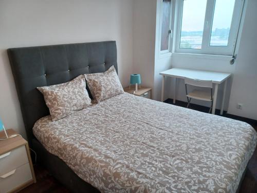 a bedroom with a bed and a desk and a window at Oporto Sea Rooms in Porto