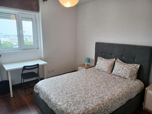 1 dormitorio con cama, escritorio y ventana en Oporto Sea Rooms, en Oporto