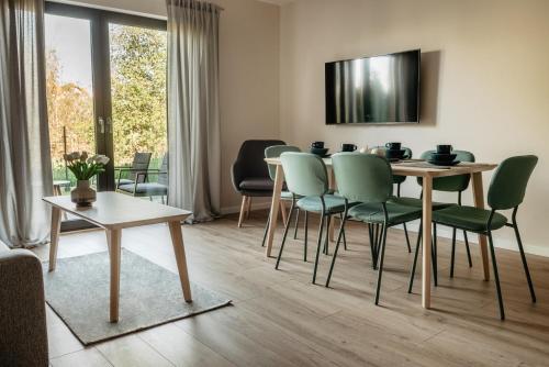 a living room with a table and chairs at lotniarzy 15 domy z widokiem na morze in Trzęsacz