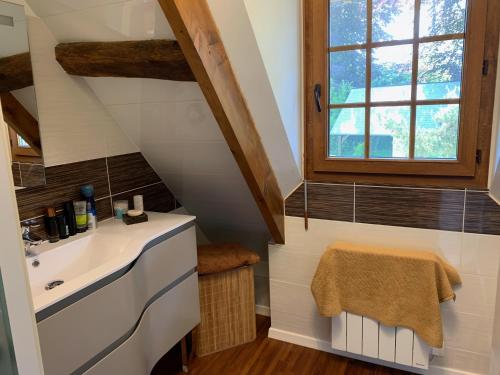 une salle de bain avec un lavabo et une fenêtre dans l'établissement Wijitta, à Auquemesnil