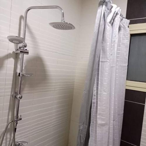 a shower with a shower curtain in a bathroom at Apt à Alexandrie cleopatra families only, KEMET in Alexandria