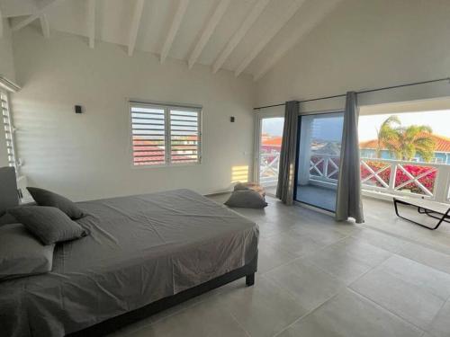 a bedroom with a large bed and a balcony at Villa Vista Montaña in Willemstad