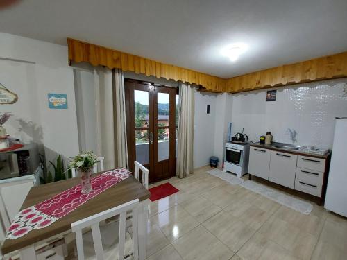 a kitchen with a table and a kitchen with a sink at loft harmonia in Blumenau