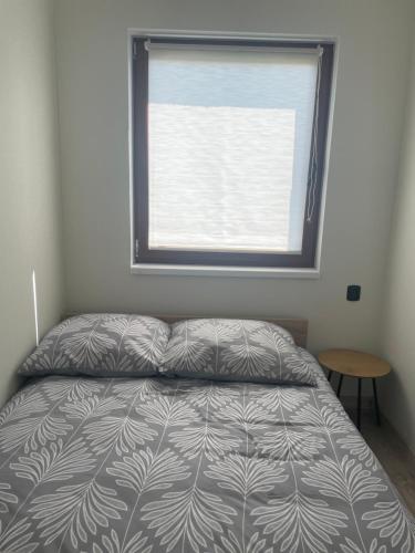 a bedroom with a bed in front of a window at PRZYSTANEK G&S in Mikoszewo