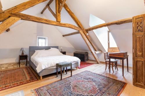 a bedroom with a bed and a table and a desk at Château D'arry Maison de Vacance in Arry