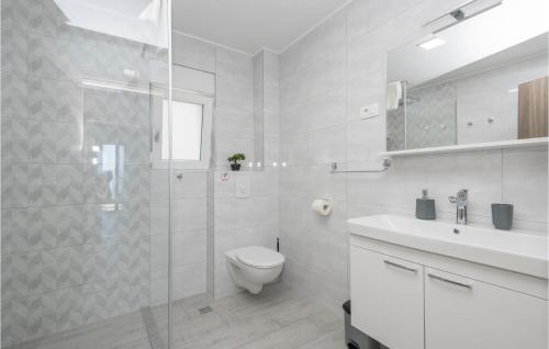 a white bathroom with a toilet and a glass shower at Awesome Apartment In Podaca With Kitchen in Podaca