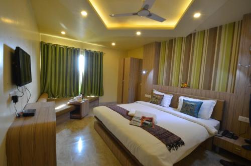 a bedroom with a large bed and a television at Hotel Banaras Haveli in Varanasi