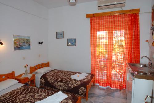 Kleines Zimmer mit 2 Betten und einem Waschbecken in der Unterkunft Stone House in Mythimna