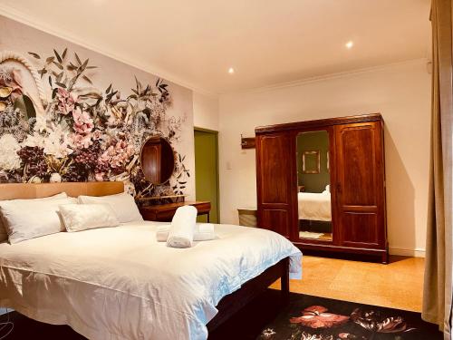 1 dormitorio con 1 cama con un mural floral en la pared en Primo farm, en Windmeul