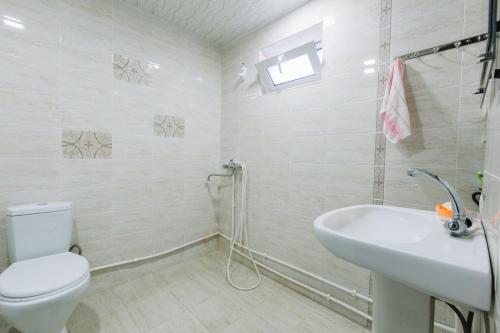 a white bathroom with a toilet and a sink at B&B Ruzan in Yeghegnadzor