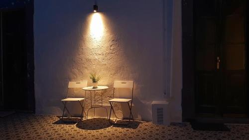 a room with three chairs and a table and a light at A Casa do Tenente in Faro