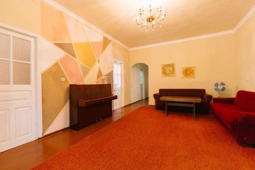 a living room with a red couch and a piano at B&B Ruzan in Yeghegnadzor
