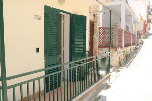 eine grüne Tür auf einem Gebäude mit einem Zaun in der Unterkunft La Casa di Lola in Alcamo