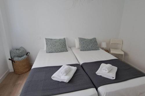 ein Schlafzimmer mit 2 Betten und Handtüchern darauf in der Unterkunft Apartamentos La Arena Zierbena 201 in Campomar
