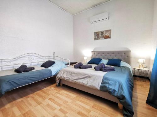 - une chambre avec 2 lits dotés d'oreillers bleus dans l'établissement L'hypercentre - Clim - Terrasse - WIFI, à Miramas