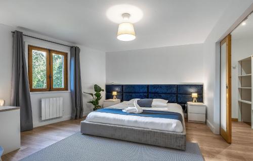 1 dormitorio con 1 cama grande y cabecero azul en Villa Nature - Maya village, en Pougny