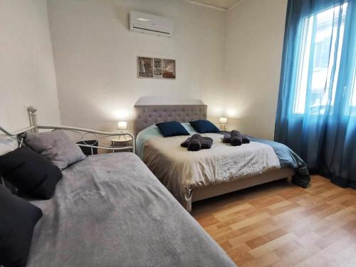 - une chambre avec 2 lits et des rideaux bleus dans l'établissement L'hypercentre - Clim - Terrasse - WIFI, à Miramas