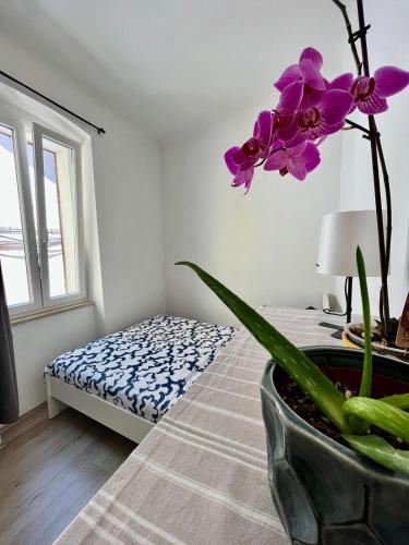 a flower in a vase on a bed in a room at Apartment JURIĆ in Lovran