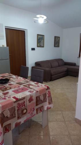 a living room with a table and a couch at Domus Claudio in Villam in Pomezia