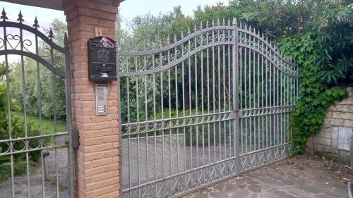 an iron gate with a mailbox next to a brick wall at Domus Claudio in Villam in Pomezia