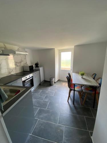 Una cocina con una mesa y un comedor. en Gîte au bord d’une rivière !, en Soultzeren