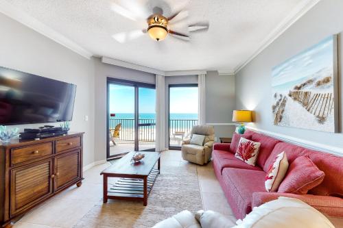 a living room with a red couch and a tv at Phoenix VI 1114 in Orange Beach