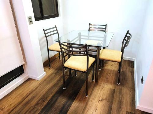 a glass table with two chairs and a glass table and chairs at Depto 2D-1B con acceso directo a playa Cau Cau in Puchuncaví